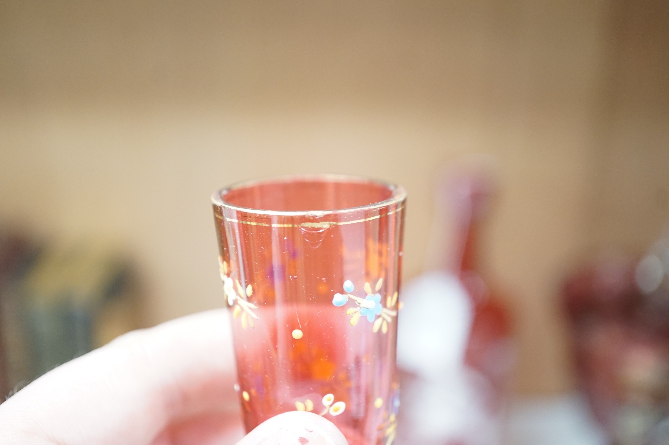 A collection of cranberry glass, a dump paperweight, another and a sweetmeat jar, tallest 28.5 cm